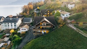 Un pueblo en una ladera con casas, una carretera y un lago al fondo.