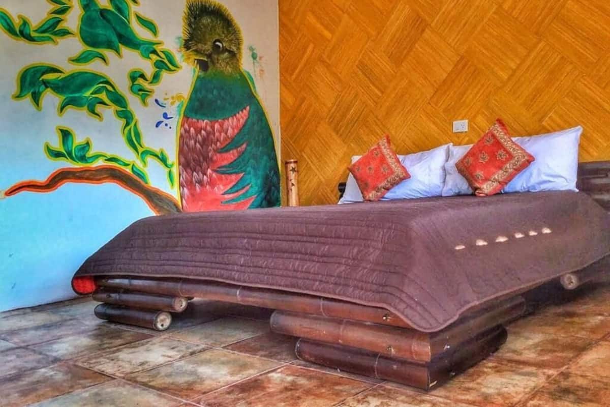Una habitación con una cama, un muro de madera y un mural.