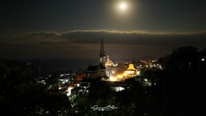 A nighttime cityscape with a prominent church and a brightly lit dome. - hotel Posada Jarritos (Cuetzalan del Progreso)
