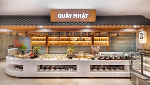 Un espace d’exposition de produits alimentaires avec une enseigne indiquant « QUAY NHAT » et divers articles alimentaires présentés.