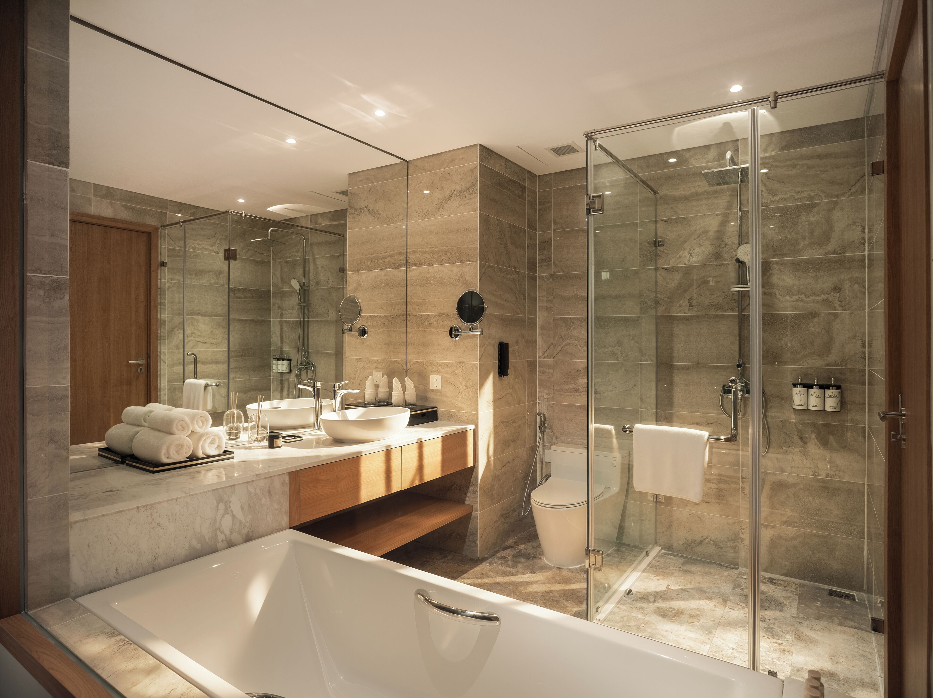 Een moderne badkamer met een badkuip, een douche met glazen wanden, een wastafelmeubel en een grote spiegel.