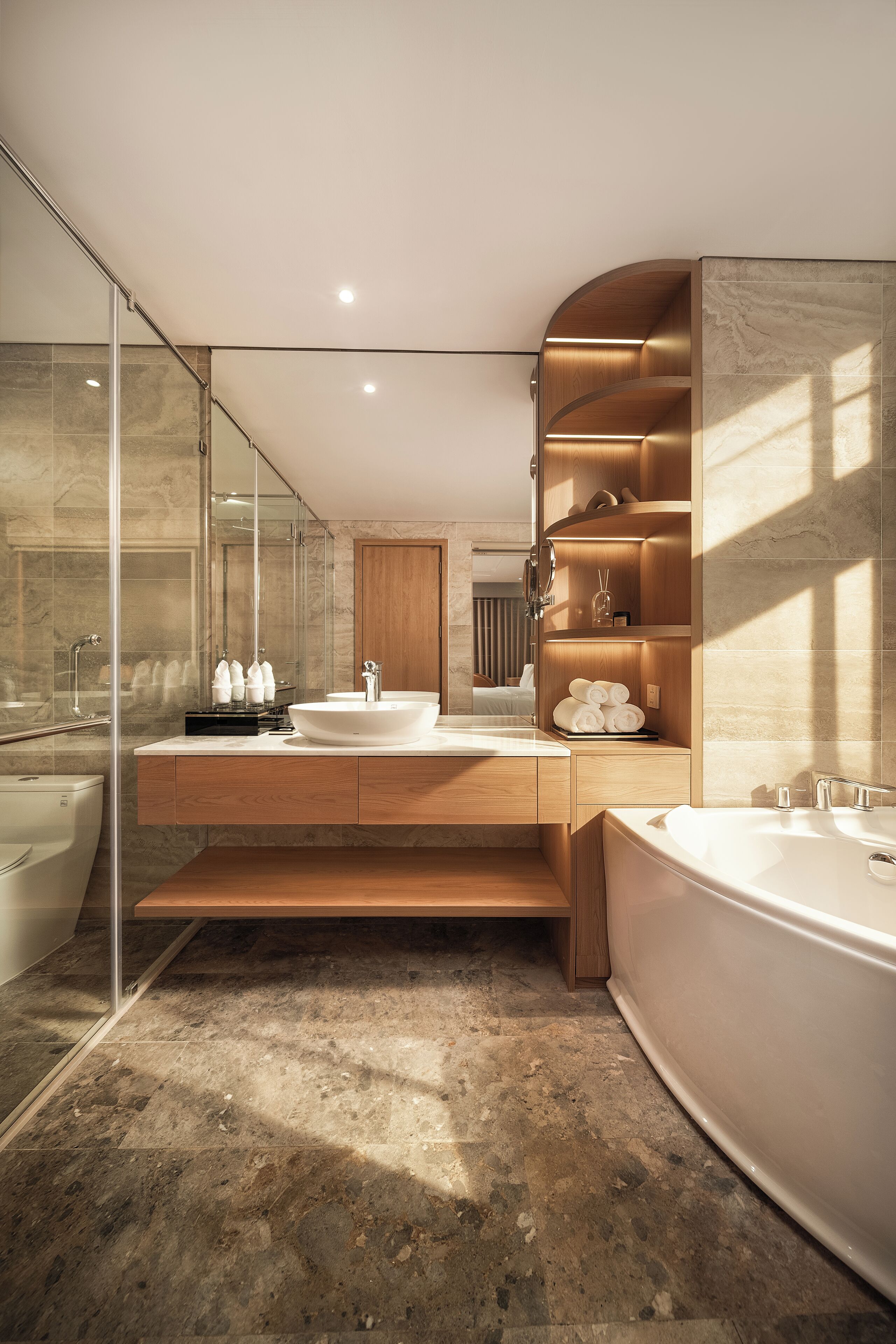 Ein modernes Badezimmer mit einer großzügigen Badewanne, einem Doppelwaschtisch und einer Duschkabine aus Glas.