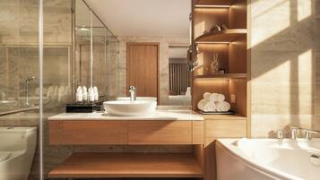Ein modernes Badezimmer mit einer großzügigen Badewanne, einem Doppelwaschtisch und einer Duschkabine aus Glas.