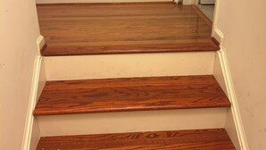 Eine Treppe mit Holzbodenstufen und weißen Wänden.