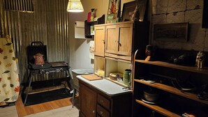 A kitchen with a vintage stove, wooden cabinets, and a countertop with various kitchen items. - THE FAR SIDE OF THE MOON
Off Grid 1-bedroom  "Cowboy Camp" in the desert (Terlingua)