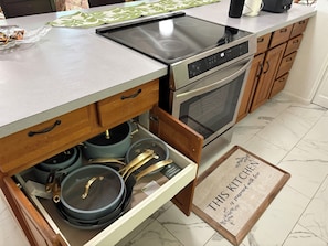 Une cuisine équipée d’une cuisinière, d’un four et d’armoires en bois.