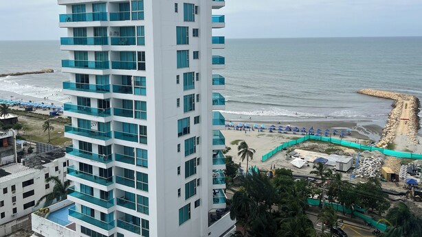 Un grand hôtel doté de nombreux balcons donnant sur une plage.
