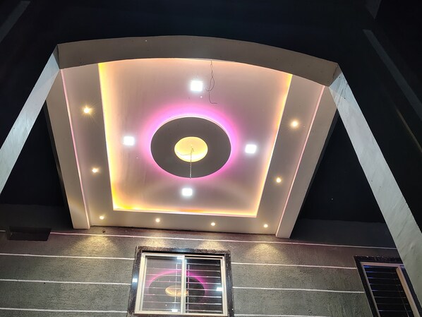 A modern building with a curved ceiling featuring recessed lighting and a central circular light fixture.