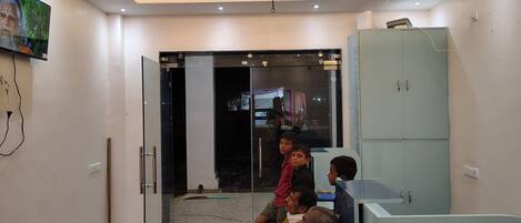 A waiting area with a glass door entrance, a ceiling light fixture, and a cabinet.