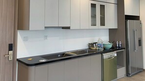 Une cuisine moderne avec des meubles de couleur claire, un réfrigérateur en acier inoxydable et un lave-vaisselle.
