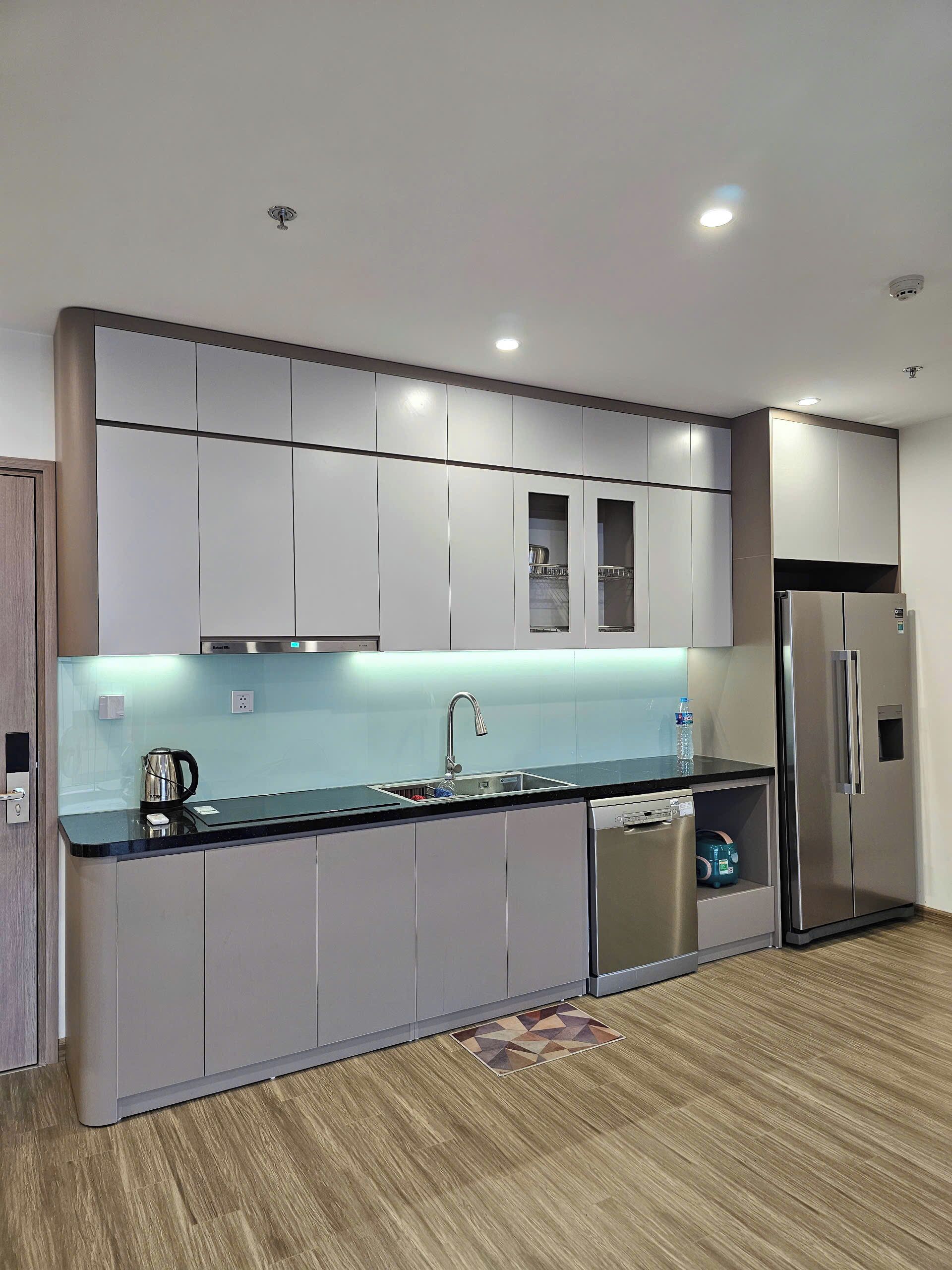 Una cocina moderna con un refrigerador de acero inoxidable, un lavavajillas integrado y una encimera elegante.
