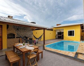 A backyard with a pool, a hammock, and a dining area with a table set for four. - PARADIS FAMILY HOME - Your beach house! (Tamoios)
