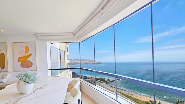 Un comedor moderno con un amplio ventanal con vistas al mar.