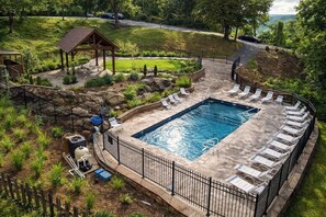 A rectangular swimming pool with lounge chairs and a covered area with a roof. - Panoramic Views•Games•HotTub •Theater•Golf•3 Pools (Gatlinburg)