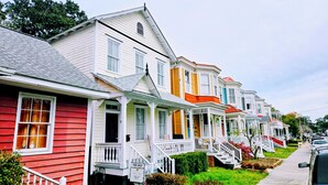 A row of colorful Victorian-style houses with front porches and bay windows.