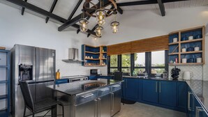 Una cocina moderna con una isla central, electrodomésticos de acero inoxidable y armarios azules.