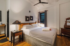 A neatly arranged bedroom with a bed, bedside tables, a ceiling fan, and a window with curtains. - Garfield Villa by TONIK (Haputale)