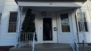 A corner building with a bay window, a front door, and a Christmas tree.