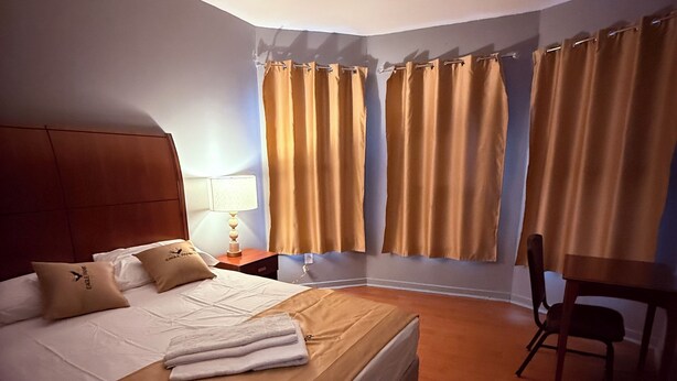 Une chambre d’hôtel avec un grand lit, un bureau et une chaise.