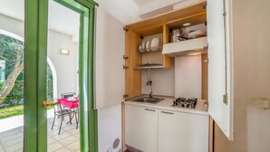 A compact kitchen with white cabinets, a stainless steel sink, and a gas stove. - Borgo Primizia M7 Pool And Sea, Otranto, Italy (Otranto)