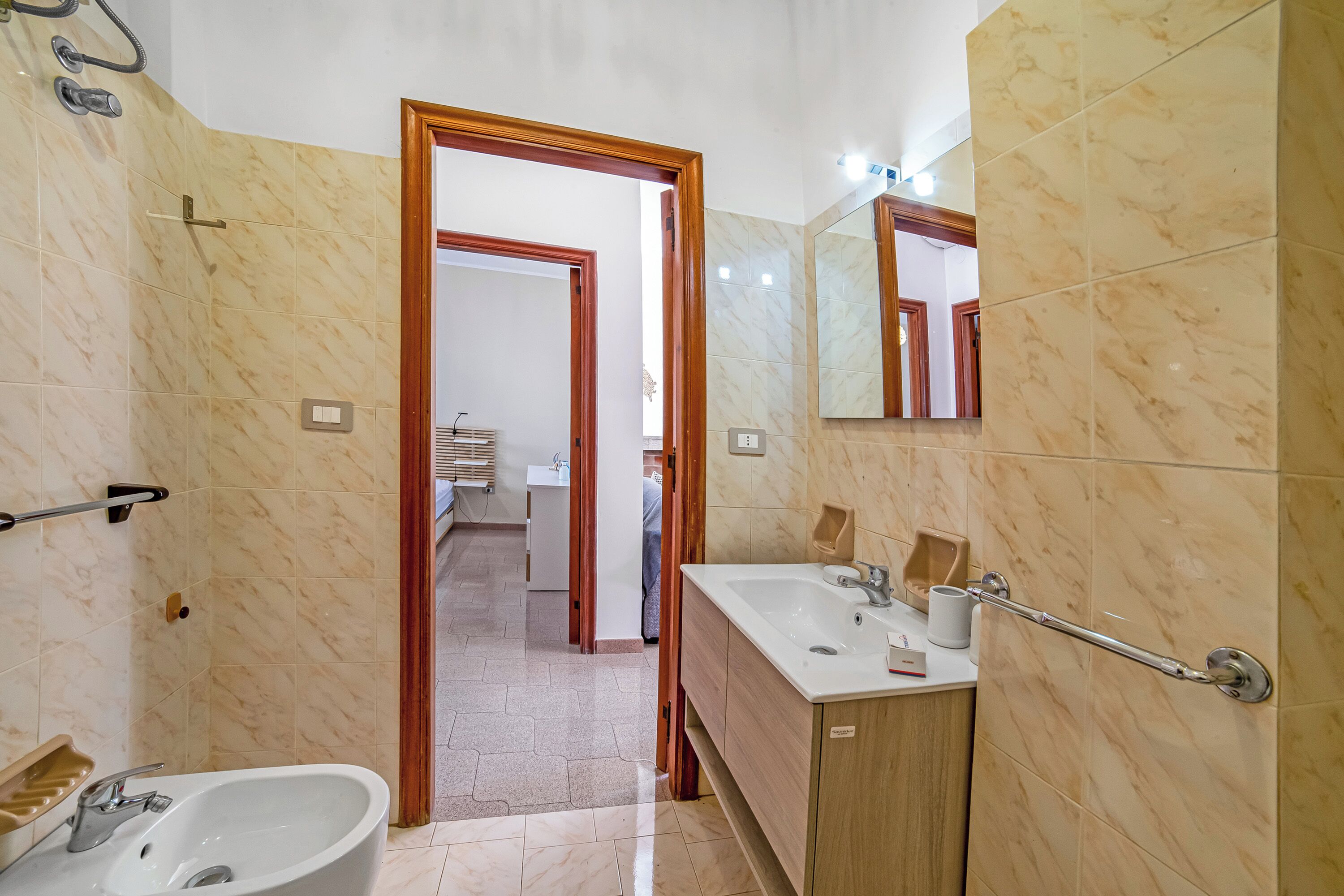 Un baño con bañera, lavamanos, espejo y cabina de ducha.