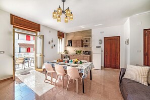 Une cuisine moderne avec un coin repas, un canapé et une vue sur l’extérieur.