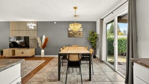 Una cocina moderna con comedor, televisor y un amplio ventanal.