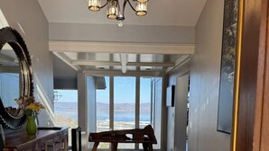 Una habitación amplia con un banco grande de madera, una mesa de comedor y una araña.
