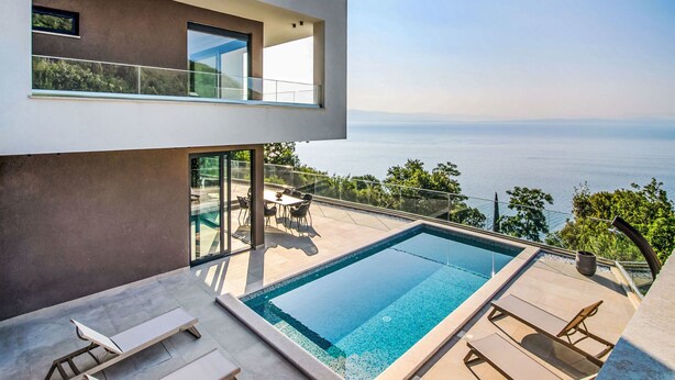 A modern house with a swimming pool, outdoor furniture, and a view of the sea. - Marmonte by Interhome (Lovran/Medveja)