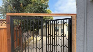 Portilla varustettu sisäänkäynti, jonka yläpuolella on puinen pergola.