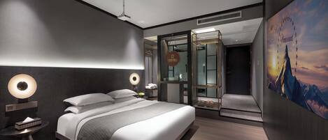 Ein modernes Hotelzimmer mit einem großen Bett, Nachttischlampen, einem Kleiderschrank und Blick auf die Stadt.