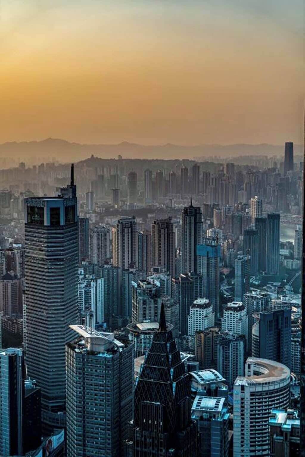 A high-rise urban skyline with modern architecture, including a distinctive tower with a spire and a curved building.