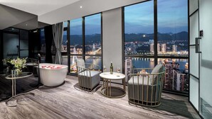 A modern room with a large window, a bathtub, and two chairs. - Chongqing Lingdu Gaokong Jiangjing Hotel (Chongqing)