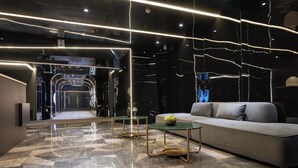 A modern lobby with a geometric floor pattern, a sofa, and tables with a minimalist design. - Chongqing Lingdu Gaokong Jiangjing Hotel (Chongqing)