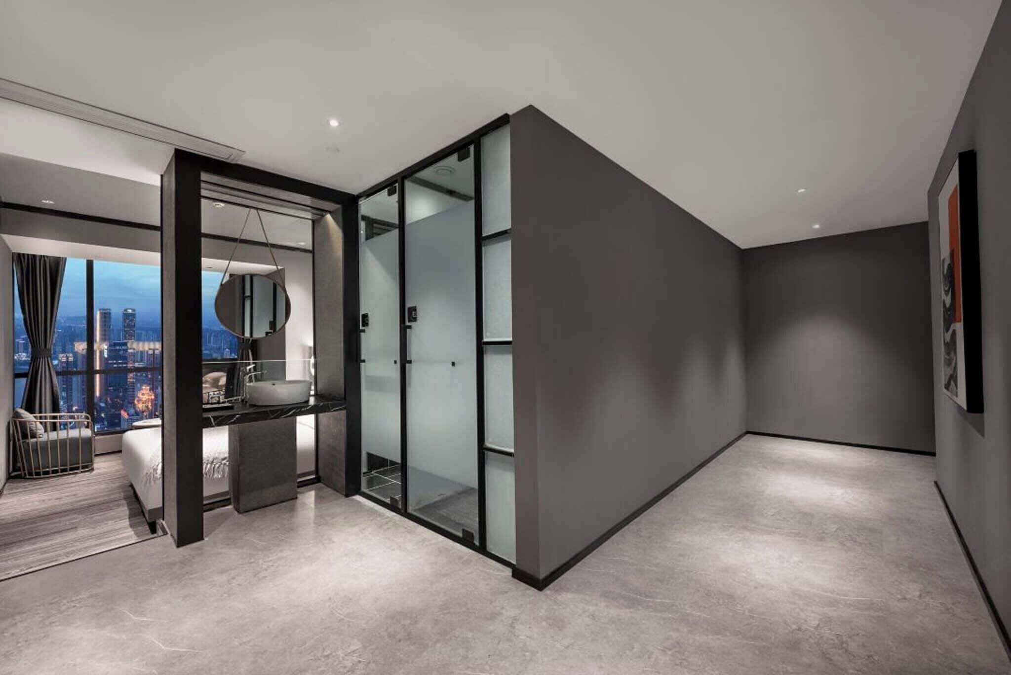 A modern hotel room with a city view, a large mirror, and a minimalist design.
