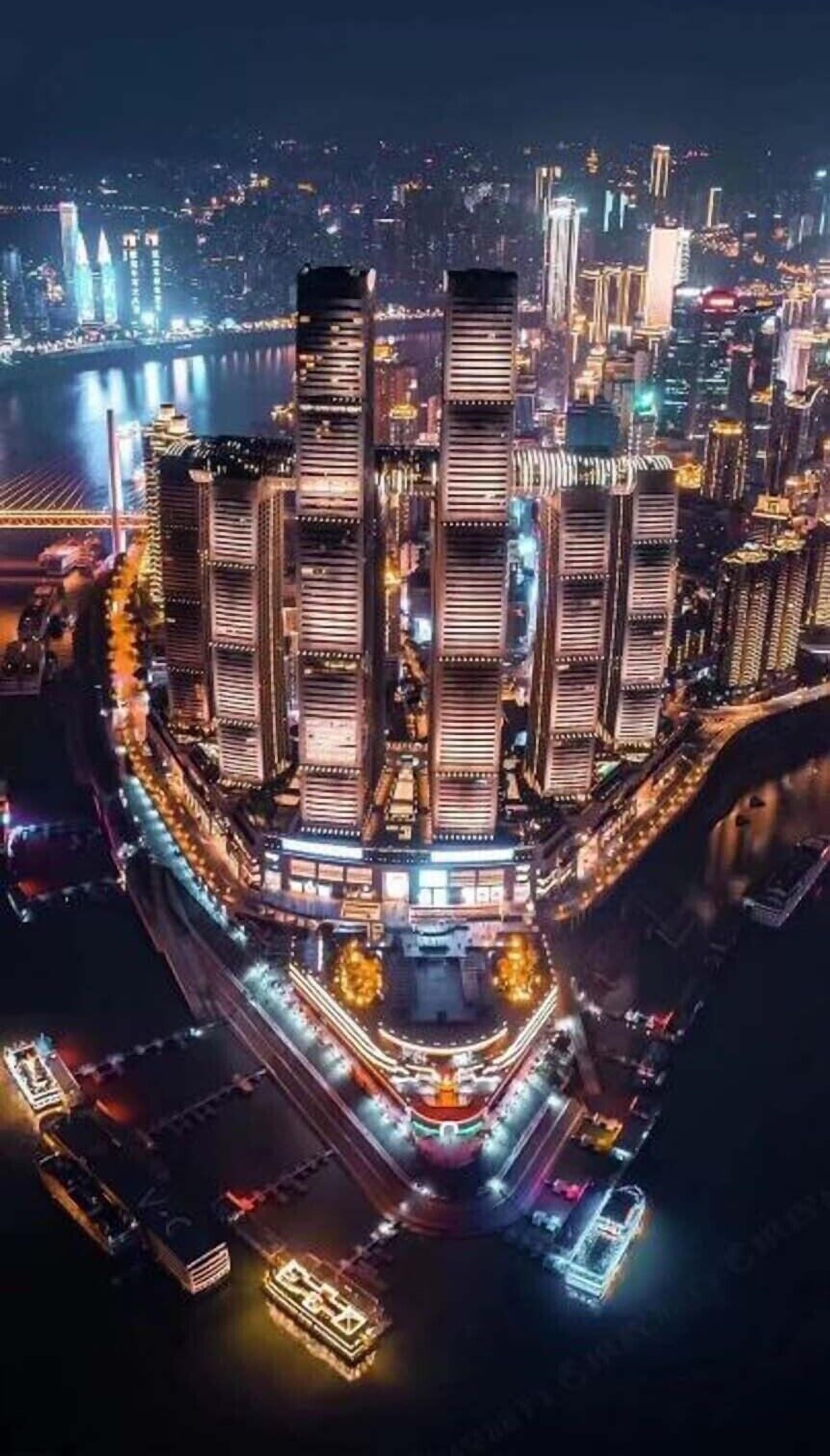 A high-rise building complex with multiple towers, surrounded by a waterfront promenade.