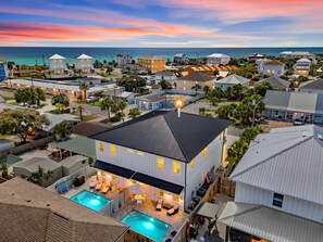 A residential area with a large house featuring a swimming pool, multiple bedrooms, and a view of the ocean. - Luxury Home, Steps to the Beach, Private Heated Pool! (Panama City)