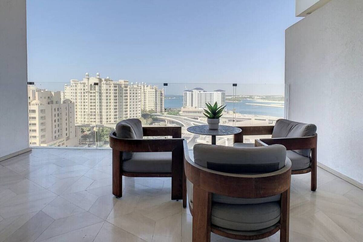 A balcony with a view of high-rise buildings and a body of water.