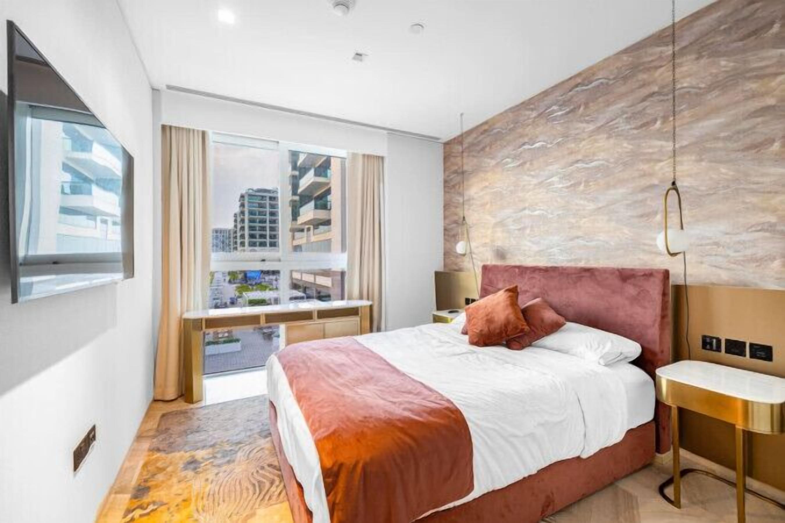 Ein modernes Hotelzimmer mit einem großen Bett, einem Schreibtisch und Blick auf die Stadtlandschaft.