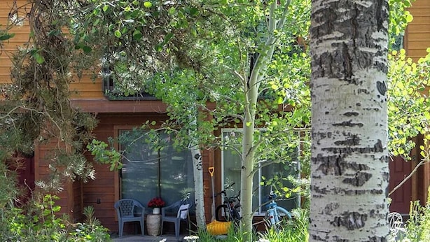 A wooden house with a covered porch, a bicycle, and a chair. - Modern Multi-level Frisco Townhome—Spacious + Central! (Frisco)