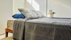 A bedroom with a bed, pillows, a nightstand, and a lamp. - Modern Multi-level Frisco Townhome—Spacious + Central! (Frisco)