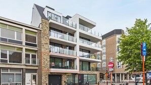 Un immeuble à plusieurs étages doté de balcons, d’un panneau indiquant un parking et d’une enseigne « Belle Epoque Centrum ».