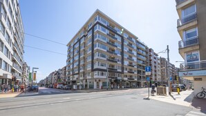 A multi-story building with a modern architectural design, featuring balconies and large windows. - Modern apartment near the sea (Middelkerke)