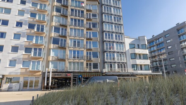 Un edificio de varios pisos con balcones, una entrada a nivel de calle y un cartel que dice 'The Gallery'.