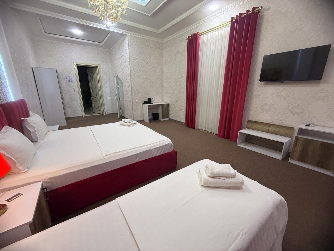 Une chambre d’hôtel avec deux lits, une télévision, un bureau et une salle de bain.