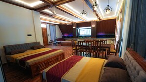 A modern RV interior with two sleeping areas, a dining area, and a kitchenette. - MOON LIGHT RESORT (Idappadi)