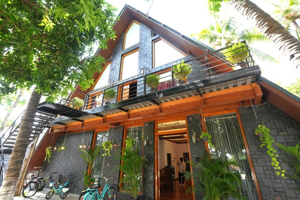 A two-story building with a balcony, a staircase, and a view of the surrounding greenery. - MOON LIGHT RESORT (Idappadi)
