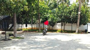 A paved outdoor area with a motorcycle, a red heart-shaped decoration, and a blue structure. - MOON LIGHT RESORT (Idappadi)
