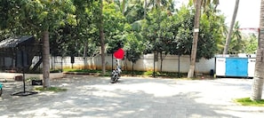 A paved outdoor area with a motorcycle, a red heart-shaped decoration, and a blue structure. - MOON LIGHT RESORT (Idappadi)