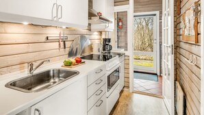 Een moderne keuken met witte kasten, roestvrijstalen apparatuur en een houten interieur.